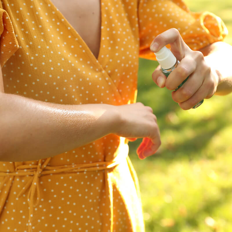 Donna che utilizza uno spray repellente per insetti realizzato con il nostro servizio di produzione prodotti repellenti conto terzi.