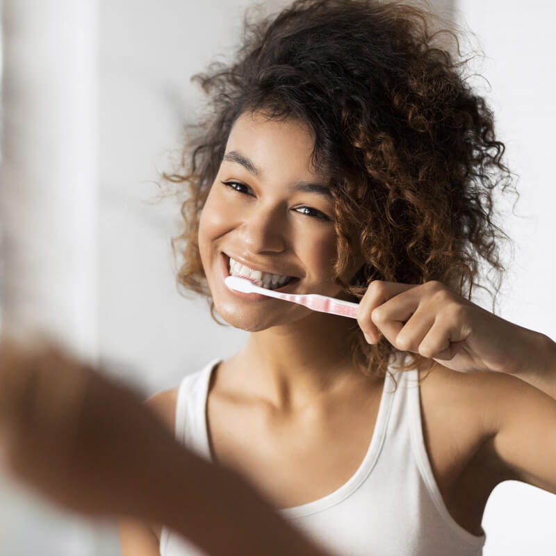 Persona che utilizza un dentifricio, realizzabile attraverso il nostro servizio di sviluppo linee di igiene orale conto terzi.