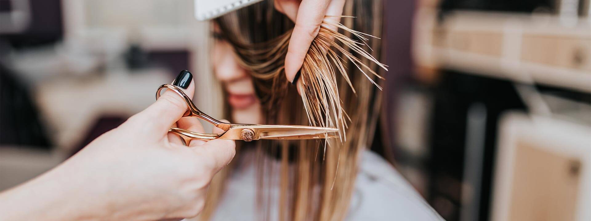 Parrucchiere professionale che taglia i capelli di una cliente, rappresentando la produzione conto terzi di prodotti per parrucchieri.