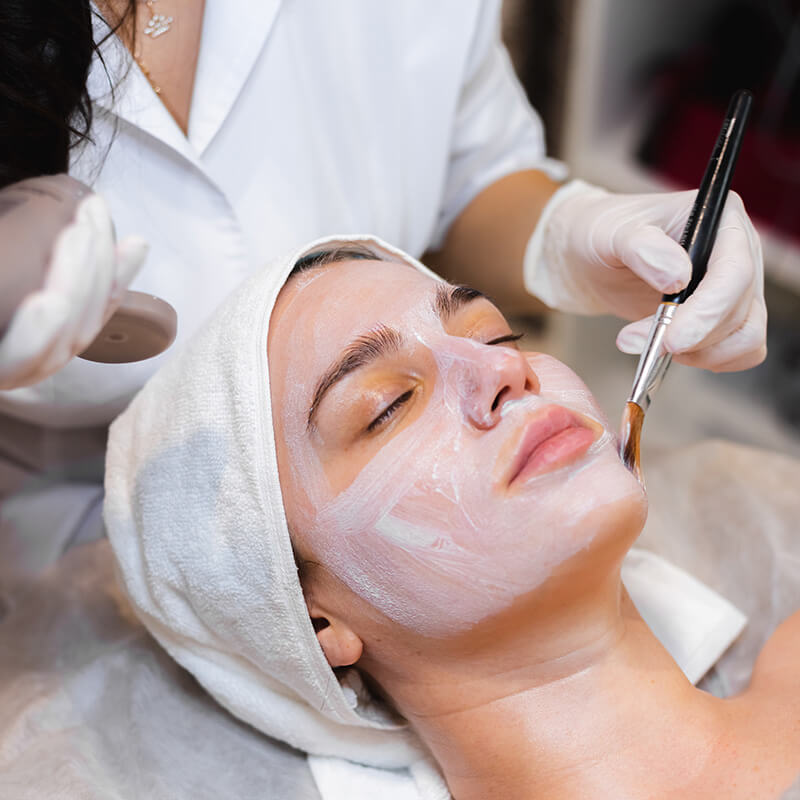 Estetista applica cosmetici personalizzati per il viso in un centro estetico.