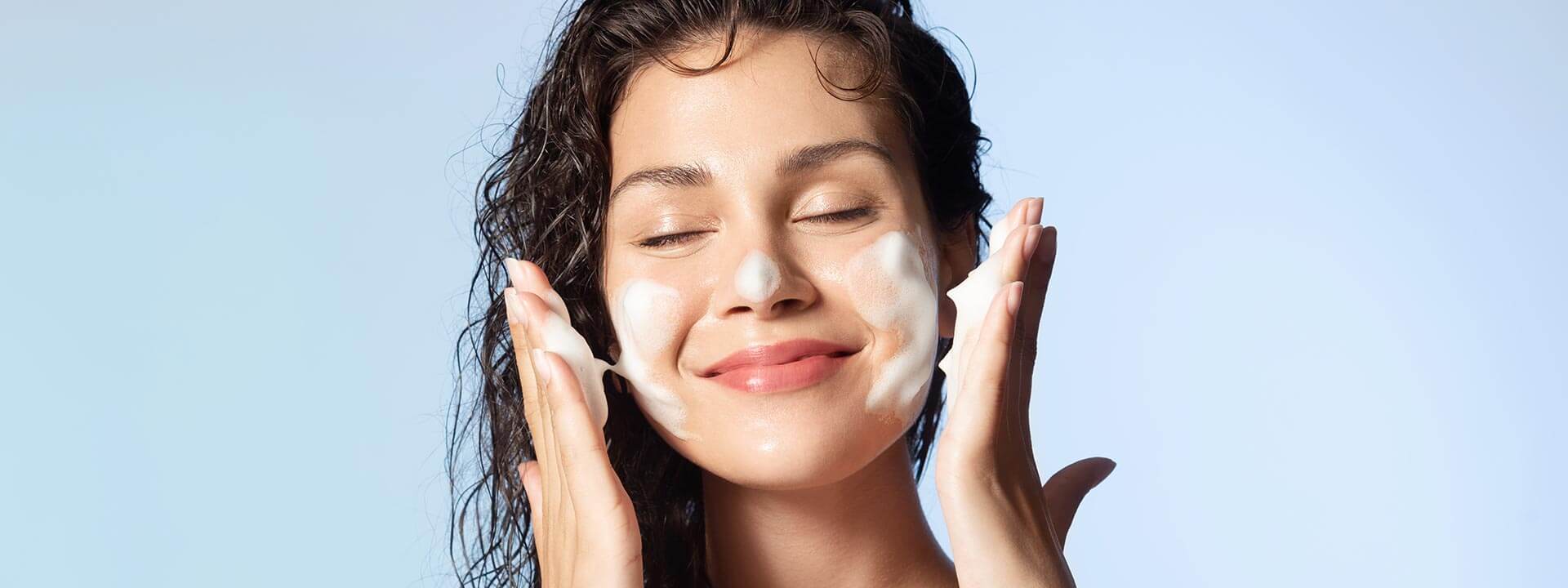 Donna applica crema viso di alta qualità per una linea skincare conto terzi personalizzata.