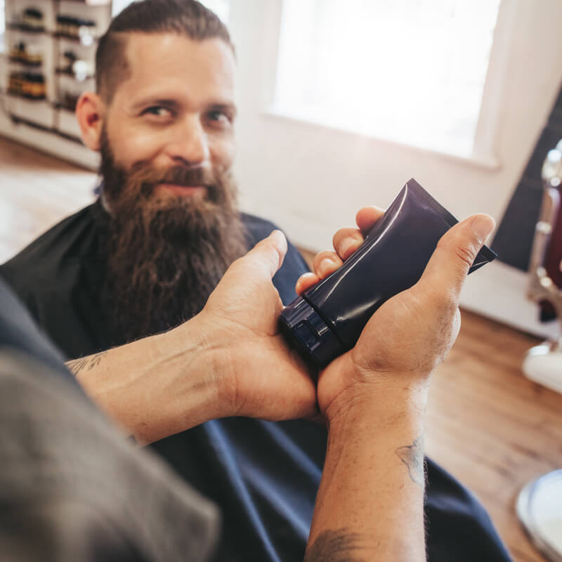 Applicazione dei cosmetici uomo conto terzi realizzati per barba e capelli.